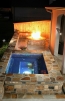 An all tiled spa with a stone fire pit built near by.